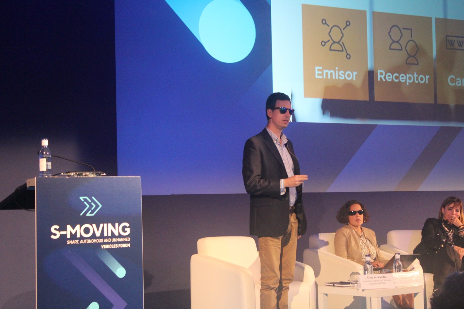 Aitor Fernández interviene de pie en el escenario de S-Moving 2018, junto a otras participantes del panel.