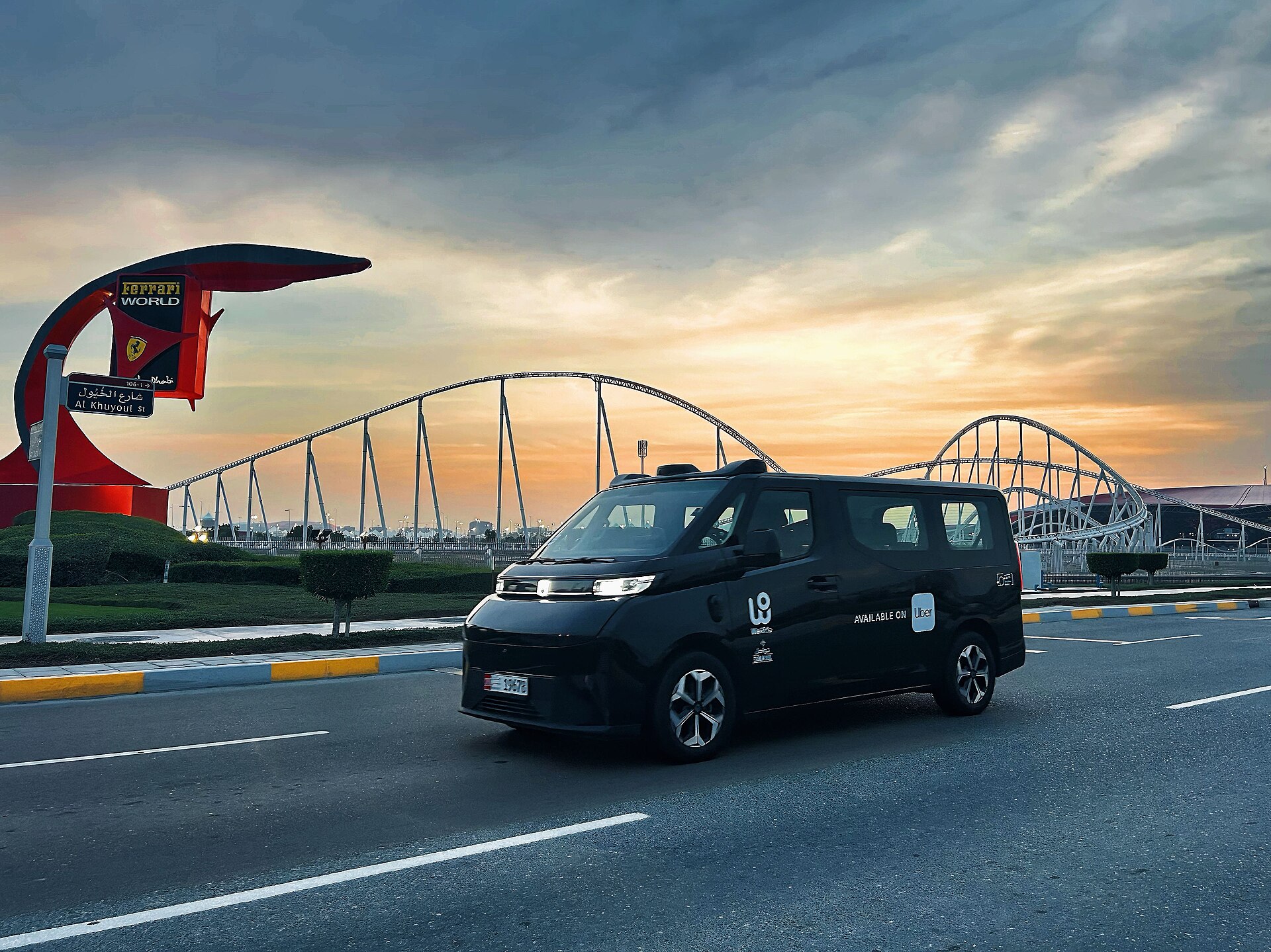 A WeRide GXR robotaxi: a black driverless van driving on a road at sunset in Dubai.